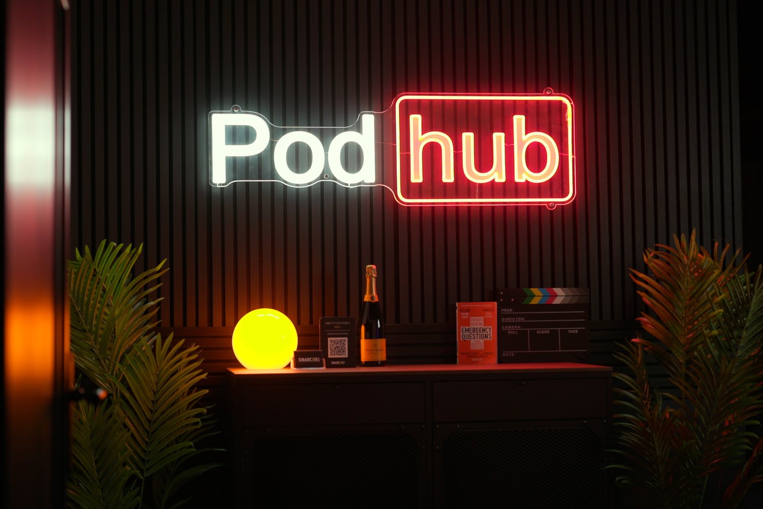 The Podhub reception counter under the neon Podhub sign